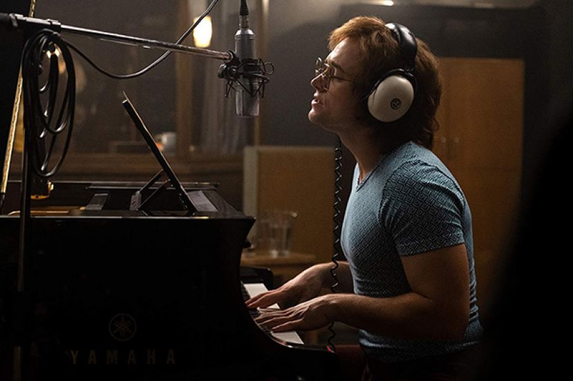 Taron Egerton playing the piamo, as Elton John, in the movie, Rocketman