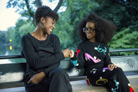 Issa Rae as April (left) and Marsai Martin, as her boss, Jordan Sanders, as a preteen girl, sitting on a park bench in the movie, Little.