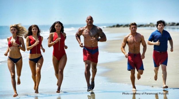 Baywatch cast from left to right: Kelly Rohrbach, Alexandra Daddario, Ifenesh Hadera, Dwayne Johnson, Zac Efron, and Jon Bass