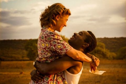 Actor, David Oyelowo, lifts and embraces actress Rosamund Pike, in the movie, A United Kingdom.  
