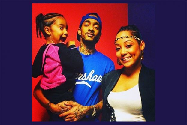 The late Nipsey Hussle (center) holding his daughter, Emani, and Tanisha Foster, mother of Emani