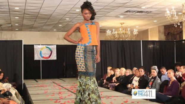 African Elegance Fashion Show model walking the runway in a African print top and long fishtail skirt